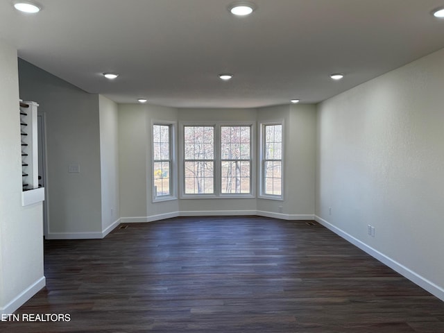 unfurnished room with dark hardwood / wood-style flooring