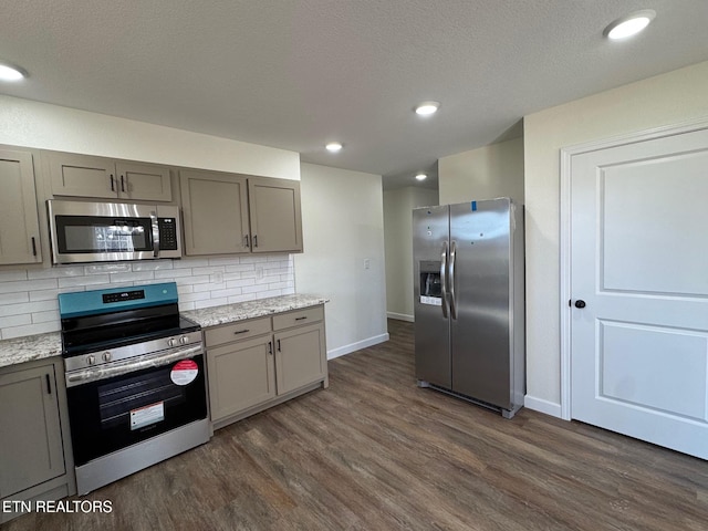 kitchen featuring light stone counters, gray cabinets, and appliances with stainless steel finishes