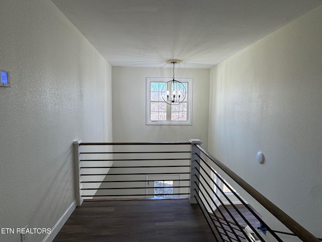 staircase with wood-type flooring and a notable chandelier