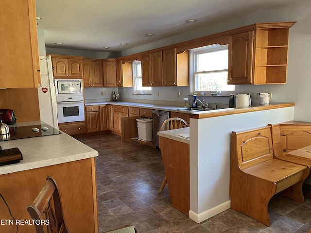 kitchen with sink, white appliances, and kitchen peninsula