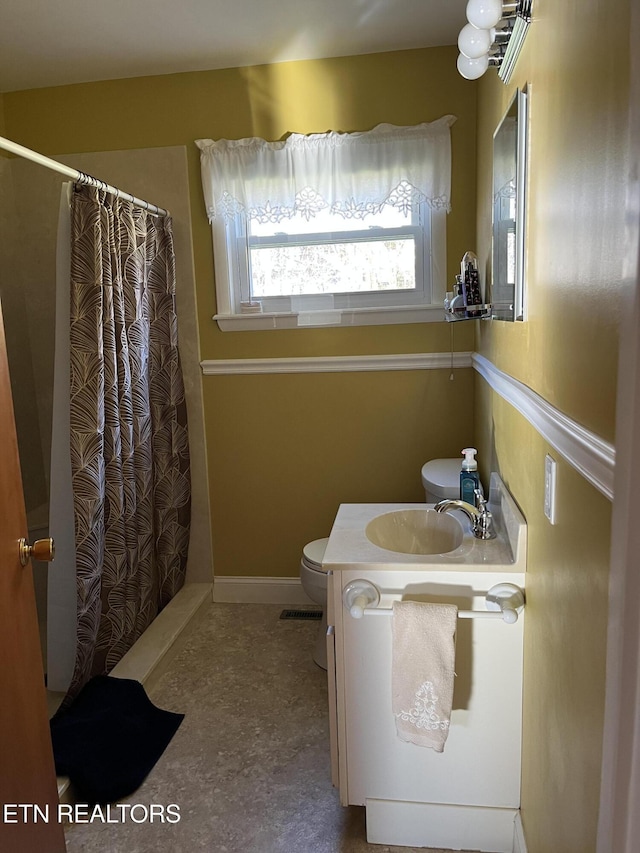 bathroom with vanity, toilet, and walk in shower