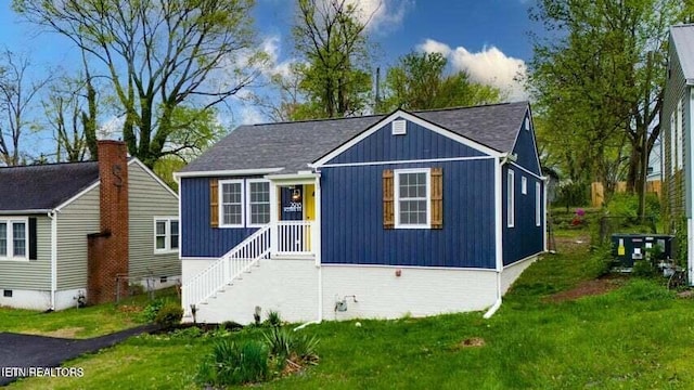 view of front of house with a front lawn and central AC unit