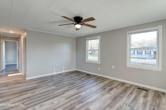 spare room featuring a wealth of natural light, ceiling fan, light hardwood / wood-style flooring, and crown molding