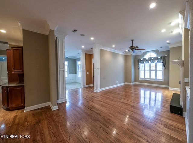 unfurnished living room with ceiling fan, wood-type flooring, and ornamental molding