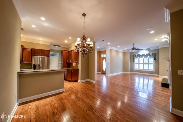 kitchen with stainless steel refrigerator with ice dispenser, pendant lighting, light wood-type flooring, ceiling fan with notable chandelier, and ornamental molding