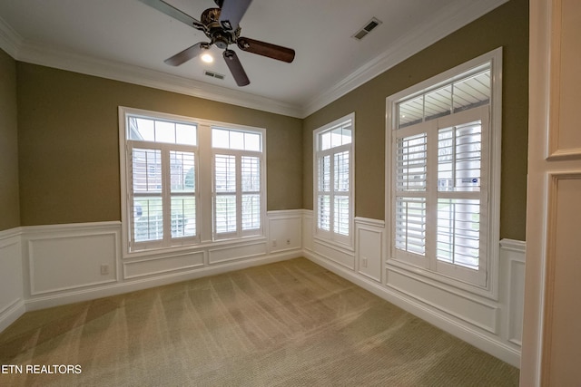 carpeted spare room featuring ceiling fan and crown molding