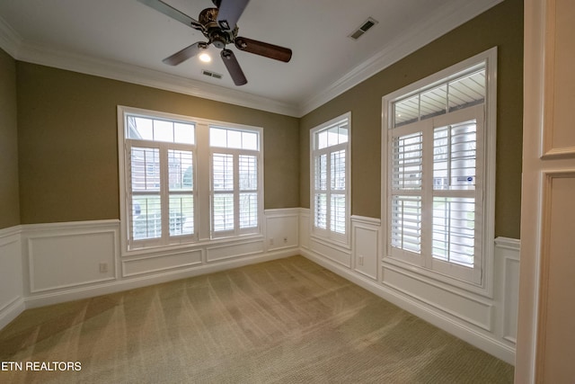 carpeted empty room with ceiling fan and crown molding