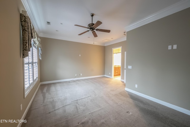 carpeted spare room with ceiling fan and ornamental molding