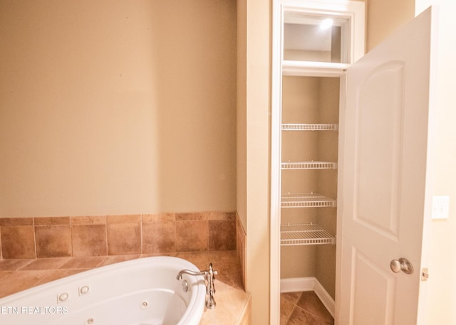 bathroom with tile patterned flooring and a tub