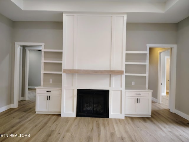 unfurnished living room featuring a fireplace and light hardwood / wood-style floors