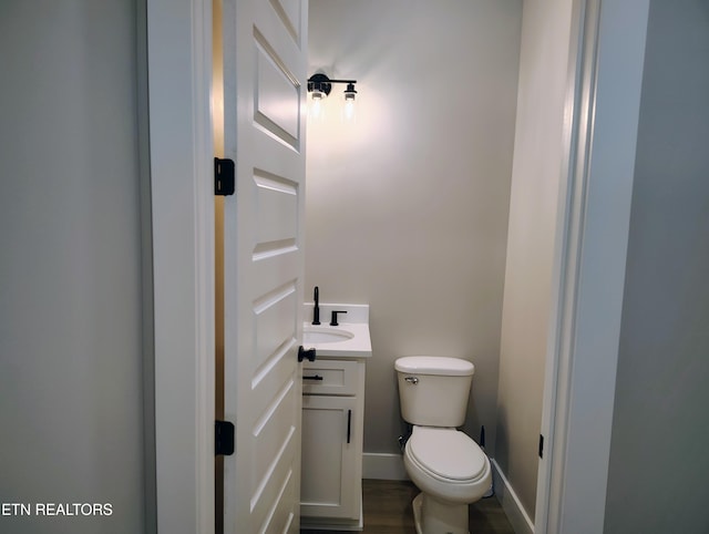 bathroom featuring vanity, wood-type flooring, and toilet