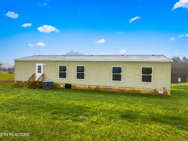 rear view of house with a lawn and central AC