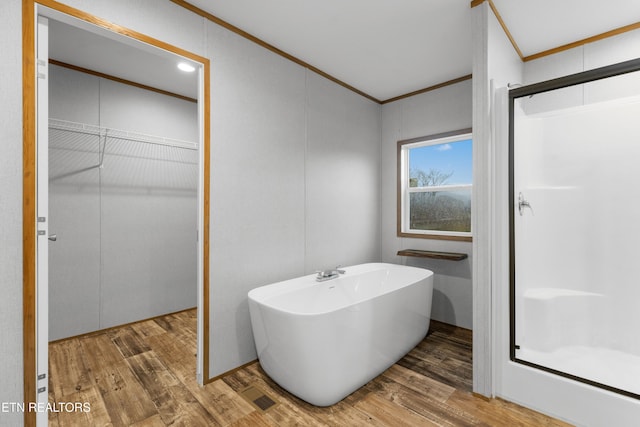 bathroom with wood-type flooring, walk in shower, and crown molding