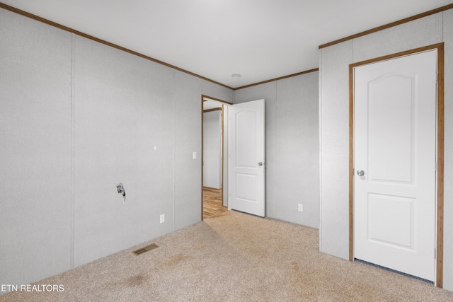 unfurnished bedroom featuring crown molding and light colored carpet