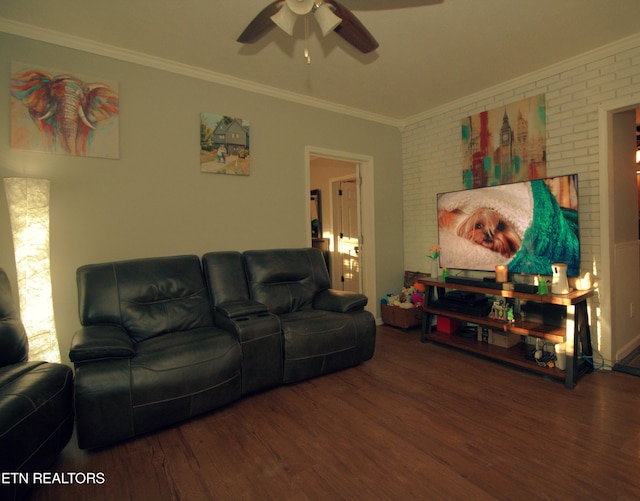 living room featuring wood-type flooring, ceiling fan, ornamental molding, and brick wall