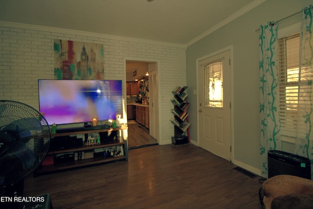 foyer with dark hardwood / wood-style flooring, crown molding, and brick wall