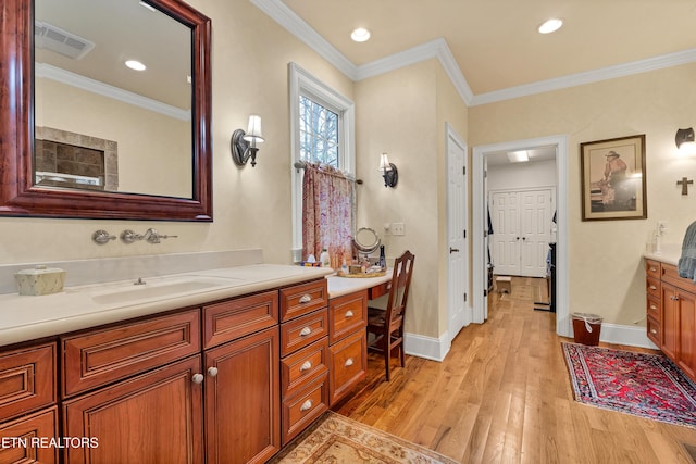 bathroom featuring hardwood / wood-style flooring, vanity, and crown molding