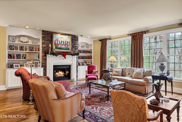 living room featuring ornamental molding, a large fireplace, and a wealth of natural light