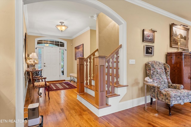 entrance foyer with crown molding and light hardwood / wood-style floors