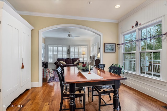 dining area with crown molding, ceiling fan, and light hardwood / wood-style flooring