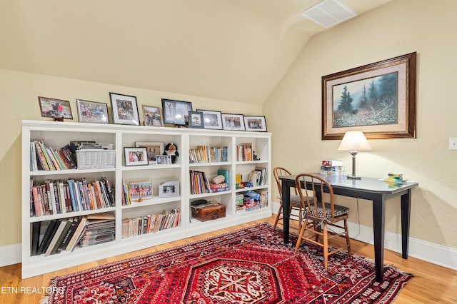 office featuring lofted ceiling and hardwood / wood-style floors