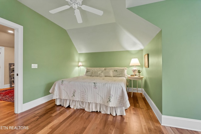 bedroom featuring hardwood / wood-style floors, vaulted ceiling, and ceiling fan