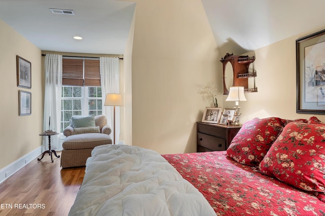 bedroom featuring lofted ceiling and hardwood / wood-style floors