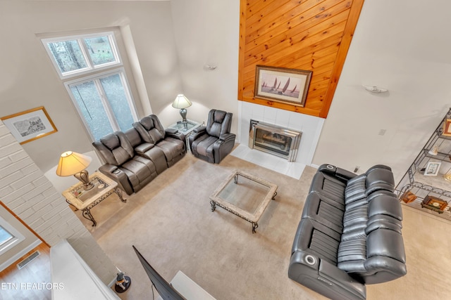 living room with a tile fireplace and a high ceiling