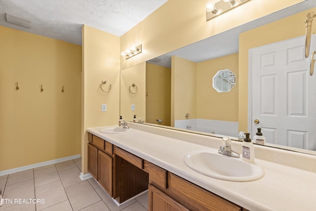 bathroom featuring a textured ceiling, a tub to relax in, tile patterned flooring, and vanity