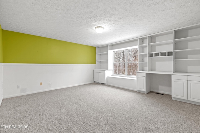 unfurnished bedroom featuring a textured ceiling and light colored carpet