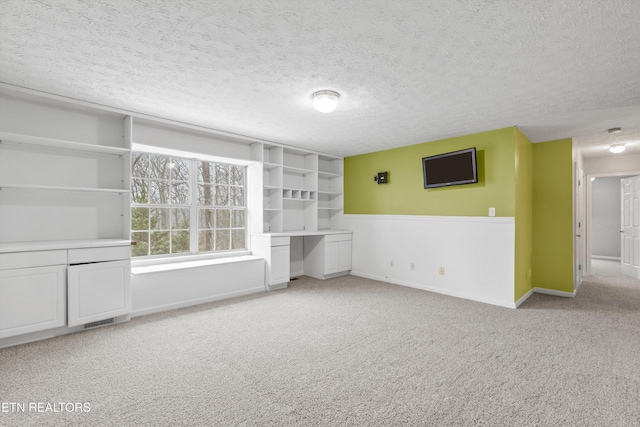 carpeted empty room featuring a textured ceiling