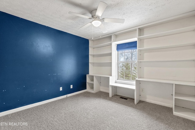 interior space with carpet flooring, a textured ceiling, and ceiling fan