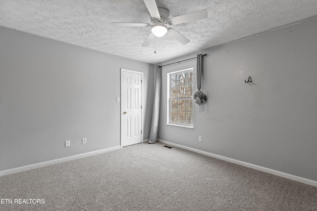 empty room featuring ceiling fan, carpet floors, and a textured ceiling