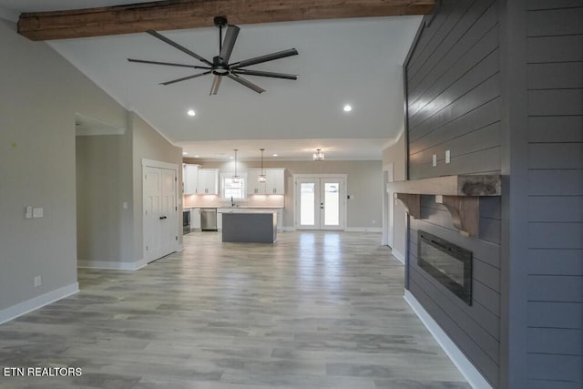 unfurnished living room with french doors, light wood-type flooring, ceiling fan, high vaulted ceiling, and beamed ceiling