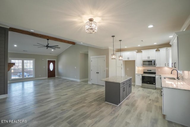 kitchen featuring a kitchen island, white cabinetry, sink, and appliances with stainless steel finishes