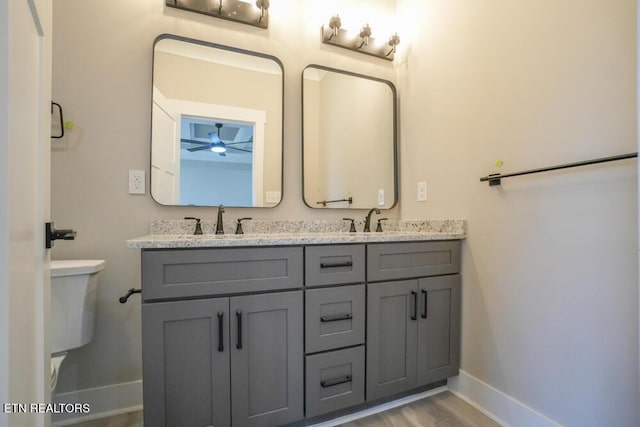 bathroom featuring hardwood / wood-style floors, vanity, ceiling fan, and toilet