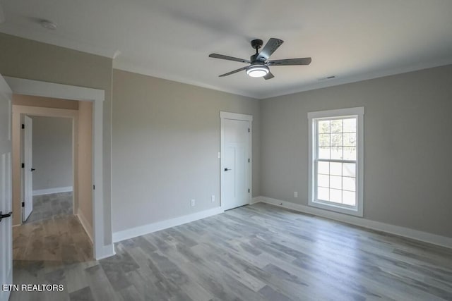 unfurnished room with ceiling fan, crown molding, and wood-type flooring