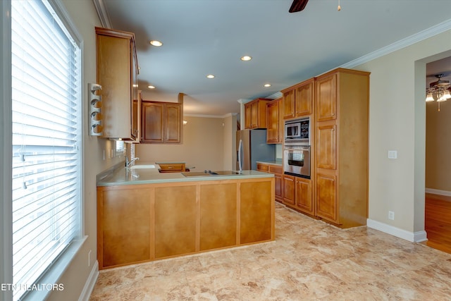 kitchen featuring sink, ornamental molding, plenty of natural light, kitchen peninsula, and stainless steel appliances