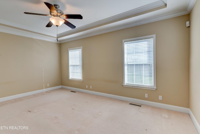 carpeted empty room featuring a tray ceiling, ceiling fan, and ornamental molding