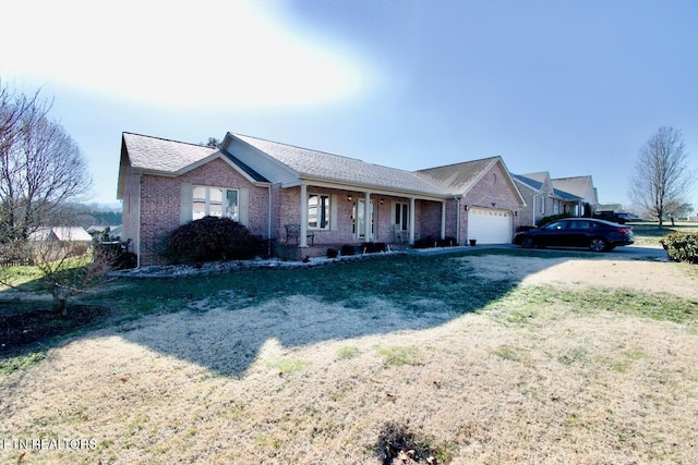 ranch-style house featuring covered porch, a garage, and a front lawn