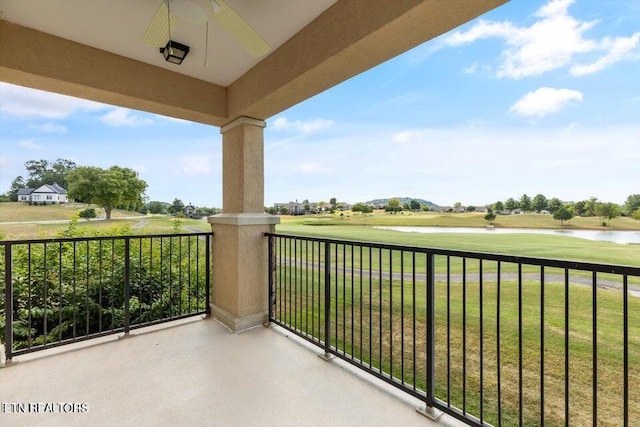 balcony with ceiling fan and a water view