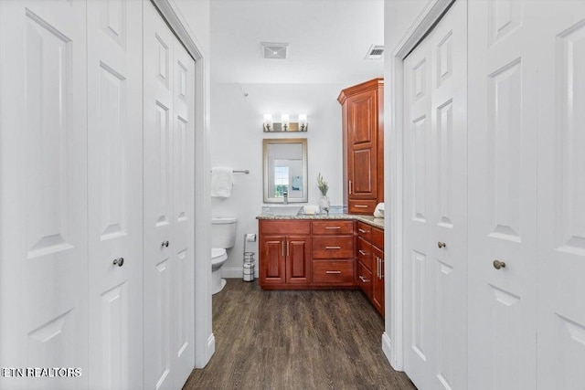 bathroom with hardwood / wood-style floors, vanity, and toilet