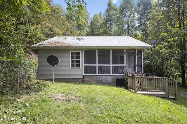 view of front of home with a sunroom and a front lawn