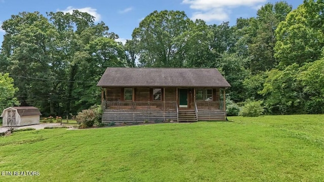 view of front facade with a storage shed, covered porch, and a front lawn