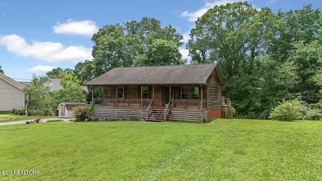 log cabin with covered porch and a front lawn