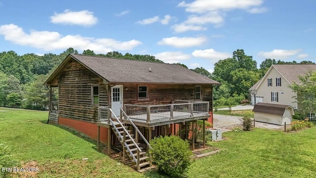 back of property featuring a wooden deck and a lawn