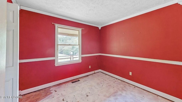 spare room with ornamental molding, concrete floors, and a textured ceiling