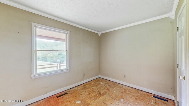 empty room with crown molding and a textured ceiling