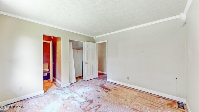 unfurnished bedroom with ornamental molding, a textured ceiling, and ensuite bathroom