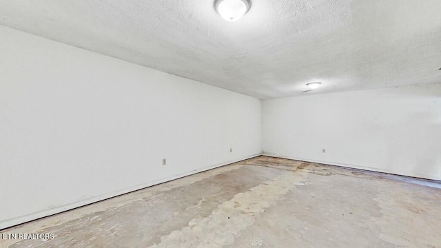 spare room with concrete flooring and a textured ceiling